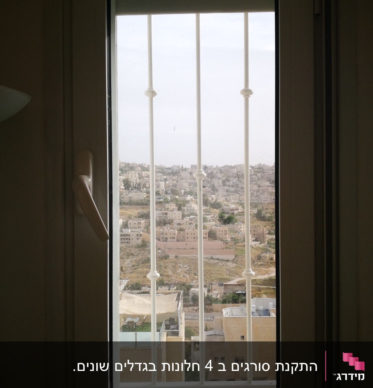 חלון עם סורגים לבנים ונוף עירוני
